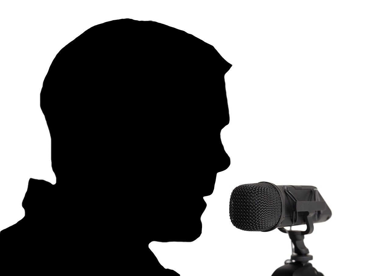 Someone talking to a microphone, as if speaking to many people